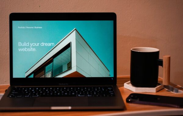 a laptop computer sitting on top of a wooden desk