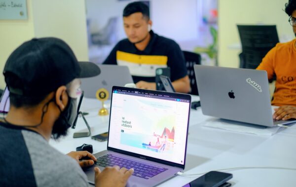 man in gray jacket using macbook pro